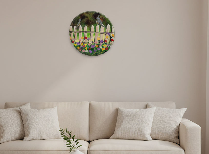 Hand painted round wall art featuring a scene with birds perched on a fence with colorful flowers in the foreground, crafted on birch wood with a glossy finish.