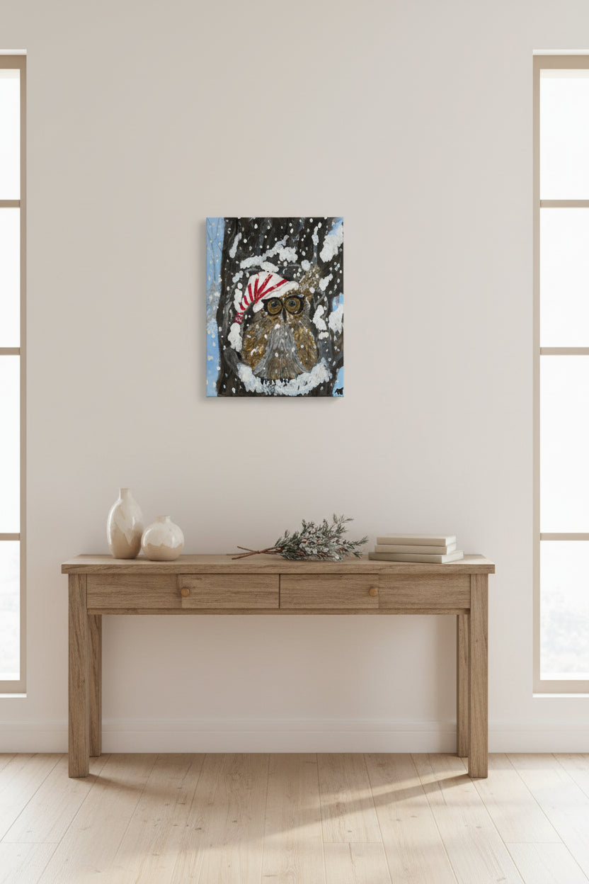 Painting of an owl wearing a Santa hat in a snowy scene on a wooden surface.